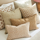 Patterned pillows on a bed with a neutral color scheme
