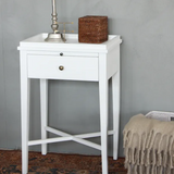White side table with a drawer against a gray wall