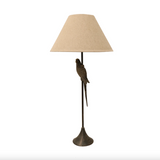 Table lamp with a bird design and beige lampshade on a white background