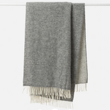 Gray throw blanket with white fringe on a white background