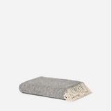 Gray throw blanket with white fringe on a white background