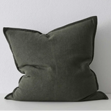 Khaki pillow on a white surface with a light gray background