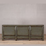 Vintage wooden sideboard with a rustic finish against a plain wall.