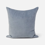 A square throw pillow in a dusty blue velvet fabric, shown against a plain light gray background.